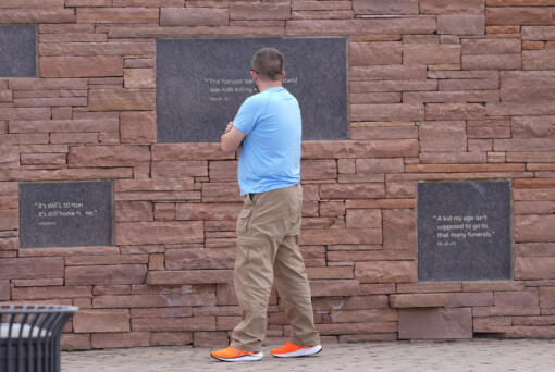A visitor looks at the plaques on the wall of healing at the Columbine Memorial, Wednesday, in Littleton, Colo. Trauma still shadows the survivors of the horrific Columbine High School shooting as the attack&rsquo;s 25th anniversary approaches.