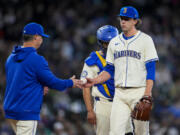 Seattle Mariners manager Scott Servais, left, takes the ball from starting pitcher Logan Gilbert as he is relieved from the game against the Arizona Diamondbacks during the seventh inning of a baseball game Sunday, April 28, 2024, in Seattle.