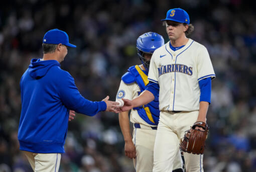 Seattle Mariners manager Scott Servais, left, takes the ball from starting pitcher Logan Gilbert as he is relieved from the game against the Arizona Diamondbacks during the seventh inning of a baseball game Sunday, April 28, 2024, in Seattle.