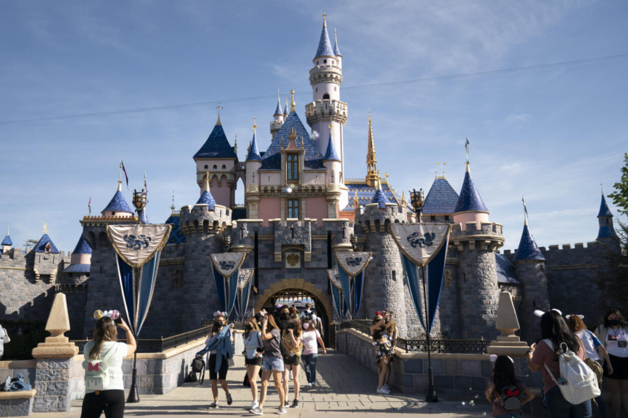 FILE - Visitors pass through Disneyland in Anaheim, Calif., April 30, 2021.  (AP Photo/Jae C.