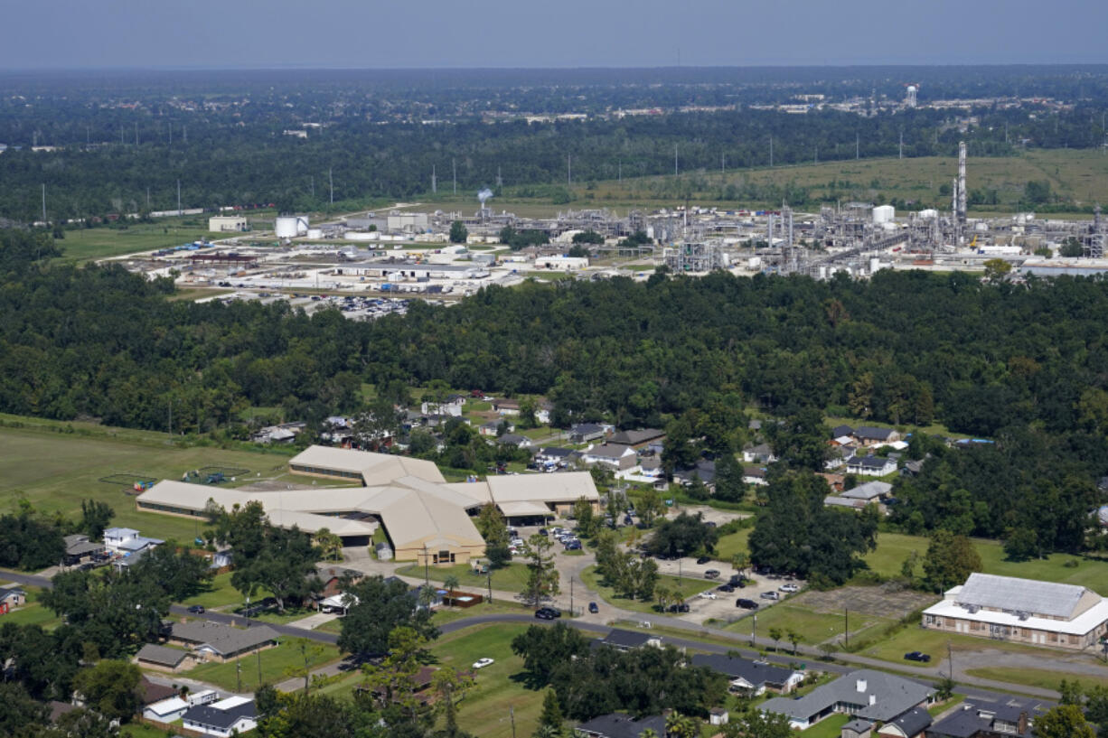 FILE - The Fifth Ward Elementary School and residential neighborhoods sit near the Denka Performance Elastomer Plant, back, in Reserve, La., Friday, Sept. 23, 2022. The Environmental Protection Agency on Tuesday, April 9, 2024, issued a rule that will force more than 200 chemical plants nationwide to reduce toxic compounds that cross beyond their property lines, exposing thousands of people to elevated cancer risks. The rule will significantly reduce harmful emissions at the Denka Performance Elastomer facility, the largest source of chloroprene emissions in the country, EPA Administrator Michael Regan said.