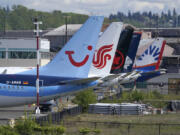 FILE - Boeing 737 Max airplanes, including one belonging to TUI Group, left, sit parked at a storage lot, Monday, April 26, 2021, near Boeing Field in Seattle.  Boeing reports earnings on Wednesday, April 24, 2024. (AP Photo/Ted S.