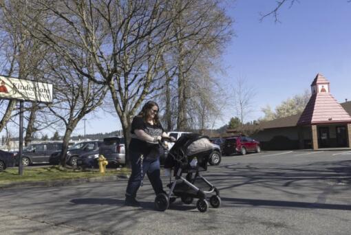 Nicole Slemp, a new mother of seven-month-old William, pushes her son in his stroller past KinderCare, which is near the family&rsquo;s home Thursday, March 14, 2024 in Auburn, Wash. Slemp recently quit her job because she and her husband couldn&rsquo;t find child care they could afford. Expensive, scarce child care is putting Puget Sound parents out of work. (Ellen M.