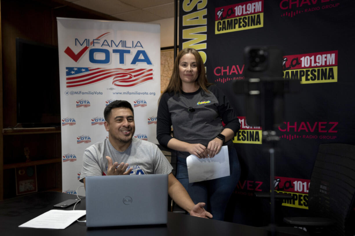 Staff members Michael Ruiz, left, and Marisol Moraga participate in a phone bank event at La Campesina, a Spanish-language radio network in Phoenix, Wednesday, March 20, 2024. A surge of misinformation is targeting Spanish-speaking voters with a high-stakes presidential election looming in the fall and candidates vying for support from the rapidly growing number of Latino voters. In one of the most important swing states, Arizona, La Campesina is countering that with a dedicated effort to provide Latino voters the facts about voting and how elections are run.