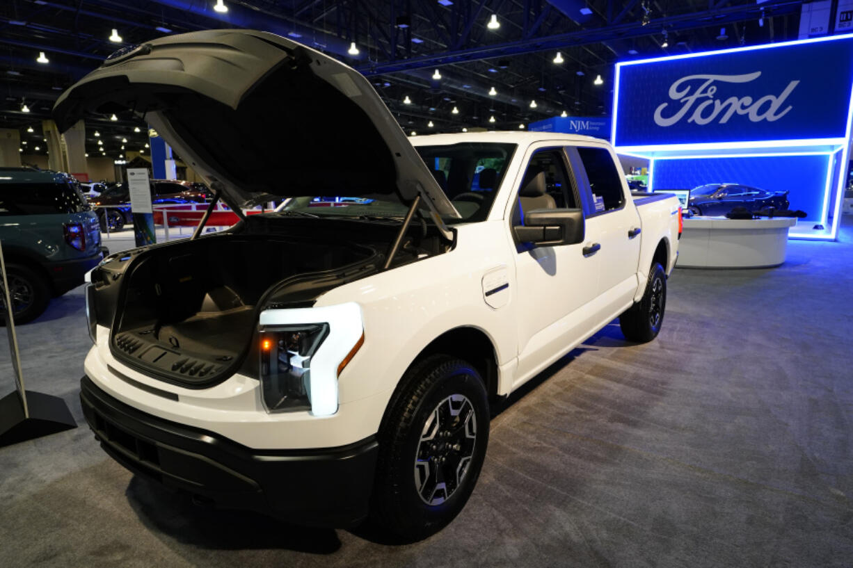 FILE - The Ford F-150 Lightning displayed at the Philadelphia Auto Show, Friday, Jan. 27, 2023, in Philadelphia.  With U.S. electric vehicle sales starting to slow, Ford Motor Co. says, Thursday, April 4, 2024,  it will delay rolling out new electric pickup trucks and a new large electric SUV as it adds gas-electric hybrids to its model lineup.