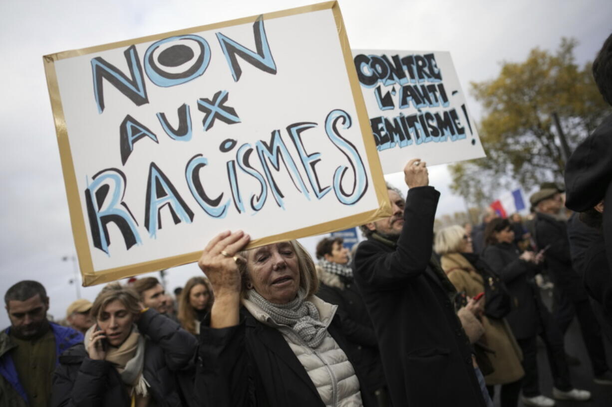 FILE - A woman carries a placard reading &ldquo; no to racism&rdquo; during a march against antisemitism in Paris, France, on Nov. 12, 2023. More than 250 Holocaust survivors have joined an international initiative to share their stories of loss and survival with students around the world during a time of rising antisemitism following the Oct. 7 Hamas attack on Israel that triggered the war in the Gaza Strip.