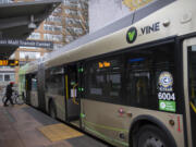A cyclist boards a C-Tran Vine bus at the Turtle Place Transit Center in downtown Vancouver in 2021.