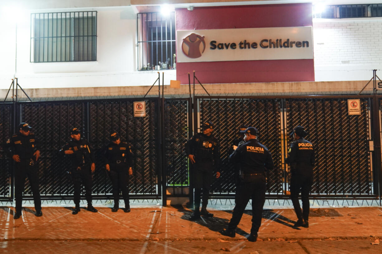 Police agents stand guard on the perimeters of the Save the Children&rsquo;s headquarters as agents from the Attorney General&rsquo;s office wind up their raid, in Guatemala City, Thursday, April 25, 2024. The NGO is being investigated for an alleged complaint about the violation of migrant children&rsquo;s rights, according to statements made by prosecutor Rafel Curruchiche.