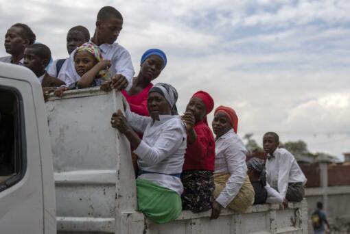 People commute on the back of a truck after attending a church service in the Petion-Ville neighborhood of Port-au-Prince, Haiti, Sunday, April 21, 2024.