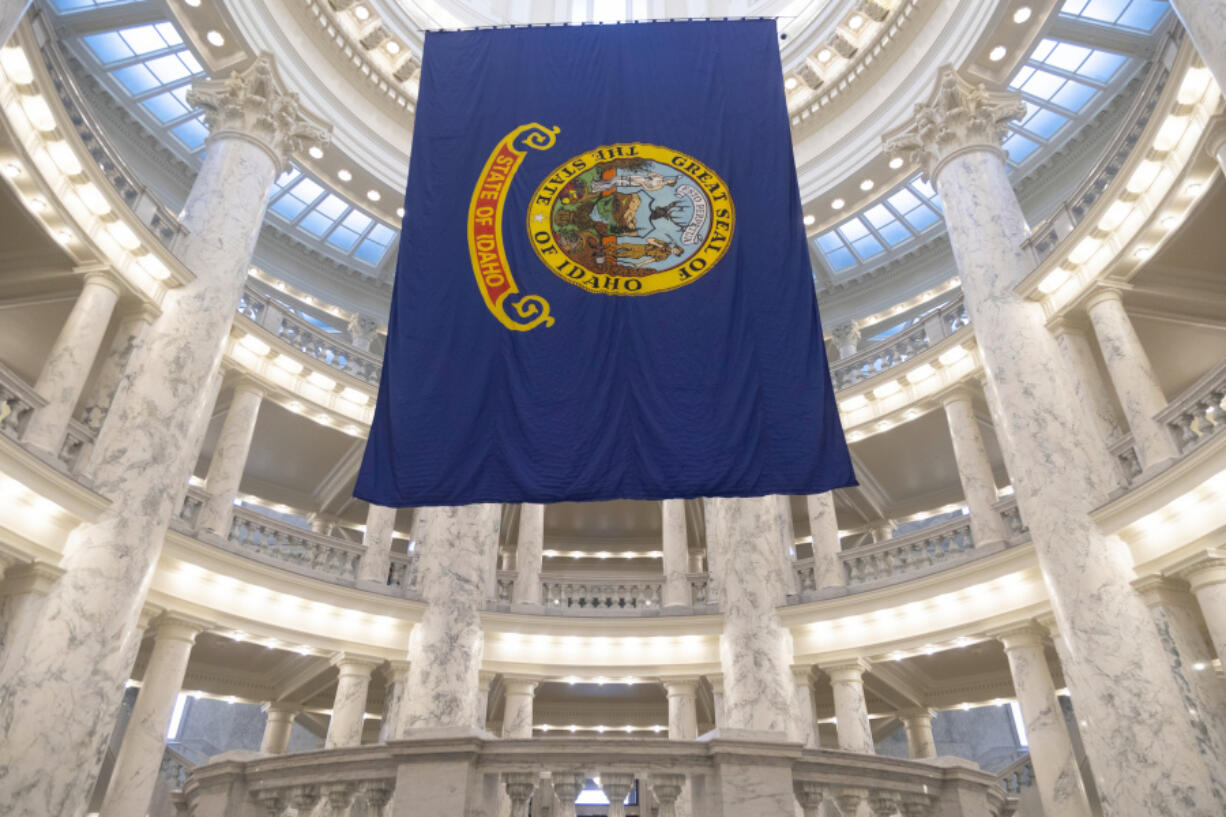 FILE - The Idaho state flag hangs in the State Capitol in Boise, Idaho, Jan. 9, 2023. Idaho lawmakers have passed a series of bills targeting LGBTQ+ residents this year, including two this week that prevent public employees from being required to use someone&rsquo;s preferred pronouns and redefine &ldquo;gender&rdquo; as being synonymous with sex.