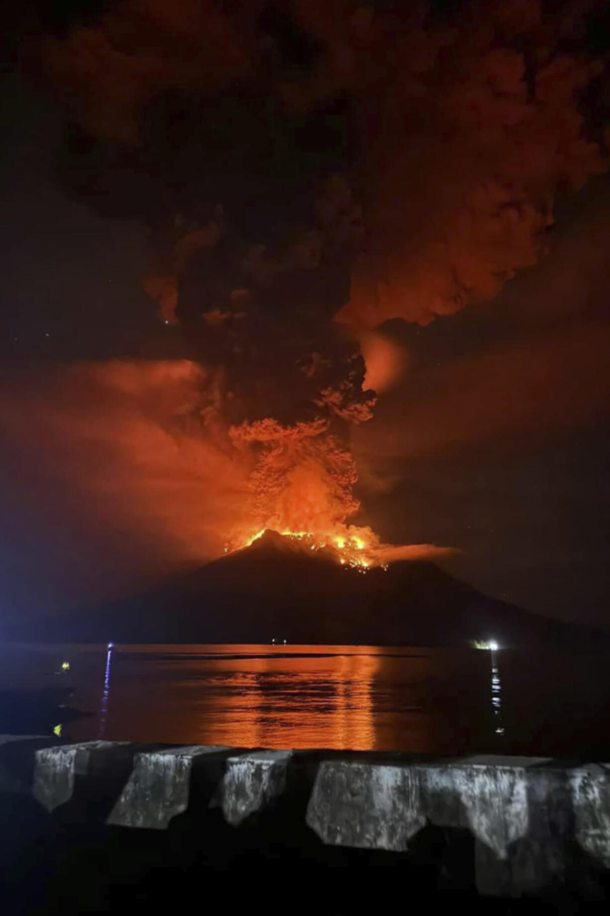 In this photo released by Sitaro Regional Disaster Management Agency (BPBD Sitaro), hot molten lava glows at the crater of Mount Ruang as it erupts in Sanguine Islands, Indonesia, Wednesday, April 17, 2024. Indonesian authorities issued a tsunami alert Wednesday after eruptions at Ruang mountain sent ash thousands of feet high. Officials ordered more than 11,000 people to leave the area.