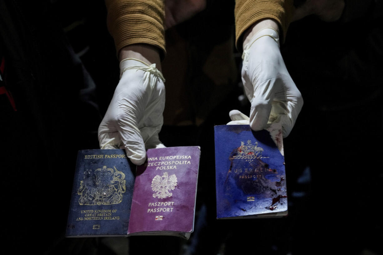 A man displays blood-stained British, Polish, and Australian passports after an Israeli airstrike, in Deir al-Balah, Gaza Strip, Monday, April 1, 2024. Gaza medical officials say an apparent Israeli airstrike killed four international aid workers with the World Central Kitchen charity and their Palestinian driver after they helped deliver food and other supplies to northern Gaza that had arrived hours early by ship.