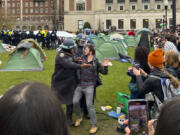 New York Police officers arrest a protestor who participated in an encampment on the Columbia University campus, Thursday, April 18, 2024, in New York. The protestors were calling for the school to divest from corporations profiting from the war in the Middle East.