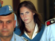 FILE - In this Sept. 26, 2008 Amanda Knox, center, is escorted by Italian penitentiary police officers to Perugia&rsquo;s court. Amanda Knox faces yet another trial for slander in a case that could remove the last remaining guilty verdict against her eight years after Italy&rsquo;s highest court definitively threw out her conviction for the murder of her 21-year-old British roommate, Meredith Kercher.