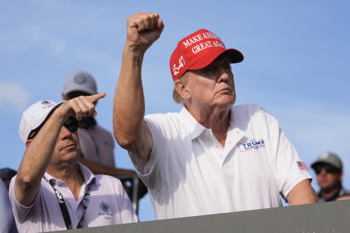 Republican presidential candidate former President Donald Trump gestures to supporters as he watches play on the 18th hole green during final round of LIV Golf Miami, at Trump National Doral Golf Club, Sunday, April 7, 2024, in Doral, Fla.