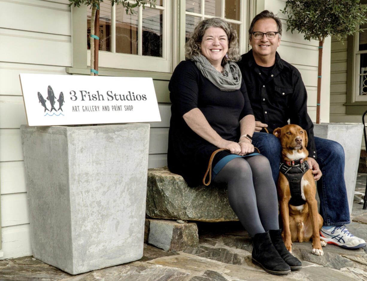 Husband and wife artist team Annie Galvin, left, and Eric Rewitzer pose with their dog Woody in front of their new 3 Fish Studios art gallery in Amador City, Calif., in 2023. Galvin and Rewitzer moved out of San Francisco to live closer to nature after their sabbatical in France and Ireland.