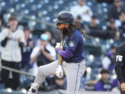 Seattle Mariners&#039; J.P. Crawford, left, reacts after reaching third base on a triple that drove in three runs off Colorado Rockies starting pitcher Peter Lambert in the second inning of the second game of a baseball doubleheader Sunday, April 21, 2024, in Denver.