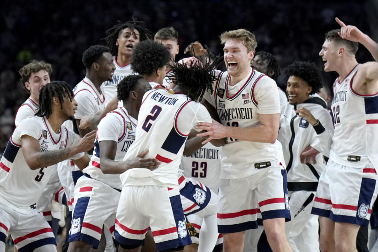 UConn players celebrate as time expires as they beat Purdue 75-60 Monday to win back-to-back NCAA national basketball championships.