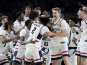 UConn players celebrate as time expires as they beat Purdue 75-60 Monday to win back-to-back NCAA national basketball championships.