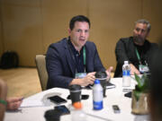 Seattle Seahawks head coach Mike Macdonald, center, talks with reporters during an NFC coaches availability at the NFL football owners meetings, Tuesday, March 26, 2024, in Orlando, Fla. (AP Photo/Phelan M.