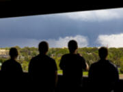 From left; Ally Mercer, Gabe Sedlacek Kaleb Andersen and Austin Young watch a tornado from a seventh floor parking garage on Friday, April 26, 2024, in Lincoln, Neb.