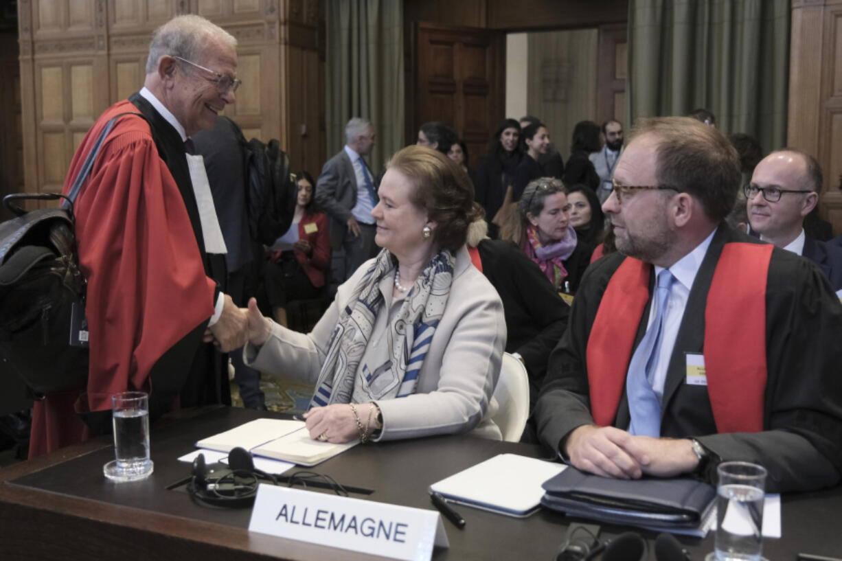 Tania von Uslar-Gleichen, Germany&rsquo;s legal adviser and Director-General for Legal Affairs of the German Foreign Ministry, center, shakes hands with Alain Pellet, left, a lawyer representing Nicaragua, prior to the start of a two days hearing at the World Court in The Hague, Netherlands, Monday, April 8, 2024, in a case brought by Nicaragua accusing Germany of breaching the genocide convention by providing arms and support to Israel.