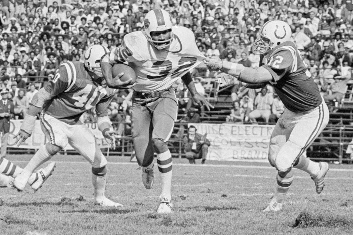 FILE - Buffalo Bulls running back O.J. Simpson (32) has his jersey pulled by Baltimore Colts linebacker Mike Curtis, during the second quarter of an NFL football game in Baltimore, Md., Oct. 12, 1975. Simpson, the decorated football superstar and Hollywood actor who was acquitted of charges he killed his former wife and her friend but later found liable in a separate civil trial, died Wednesday, April 11, 2024, of prostate cancer. He was 76.