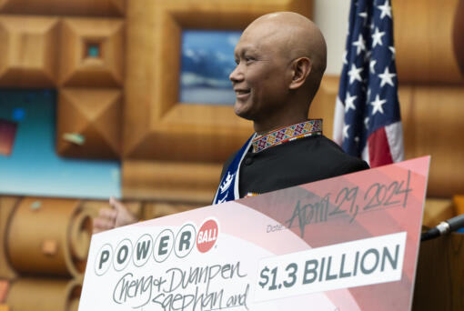 Cheng "Charlie" Saephan holds display check before speaking during a news conference where it was revealed that he was one of the winners of the $1.3 billion Powerball jackpot at the Oregon Lottery headquarters on Monday, April 29, 2024, in Salem, Ore.