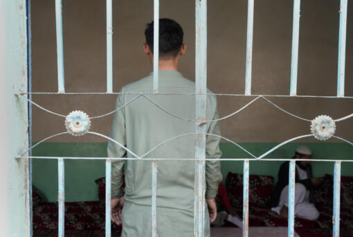 An 18-year-old Afghan boy, who asked not to use his name and not to show his face fearing his identity could lead to his capture again, pose for photograph behind a window during an interview with The Associated Press, in Karachi, Pakistan, Friday, Jan. 26, 2024. Born and raised in Pakistan to parents who fled neighboring Afghanistan half a century ago, an 18-year-old found himself at the mercy of police in Karachi who took his cash, phone and motorbike, and sent him to a deportation center.