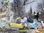 FILE - A person walks past an art installation outside a United Nations conference on plastics on April 23, 2024, in Ottawa, Ontario.