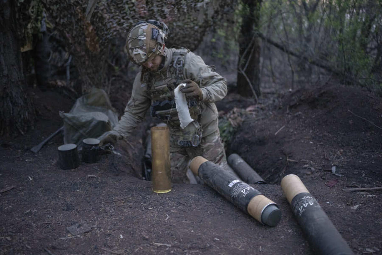 A Ukrainian serviceman from Azov brigade, 20, prepares shells for the OTO Melara Mod 56 howitzer Thursday on the frontline in the Donetsk region of eastern Ukraine.