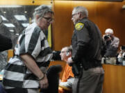 Jennifer Crumbley, walks by her husband James Crumbley, seated, as she is escorted out of court after their sentencing, Tuesday, April 9, 2024, in Pontiac, Mich.  The Crumbleys, the parents of a Michigan school shooter, were sentenced to at least 10 years in prison Tuesday for failing to take steps that could have prevented the killing of four students in 2021.