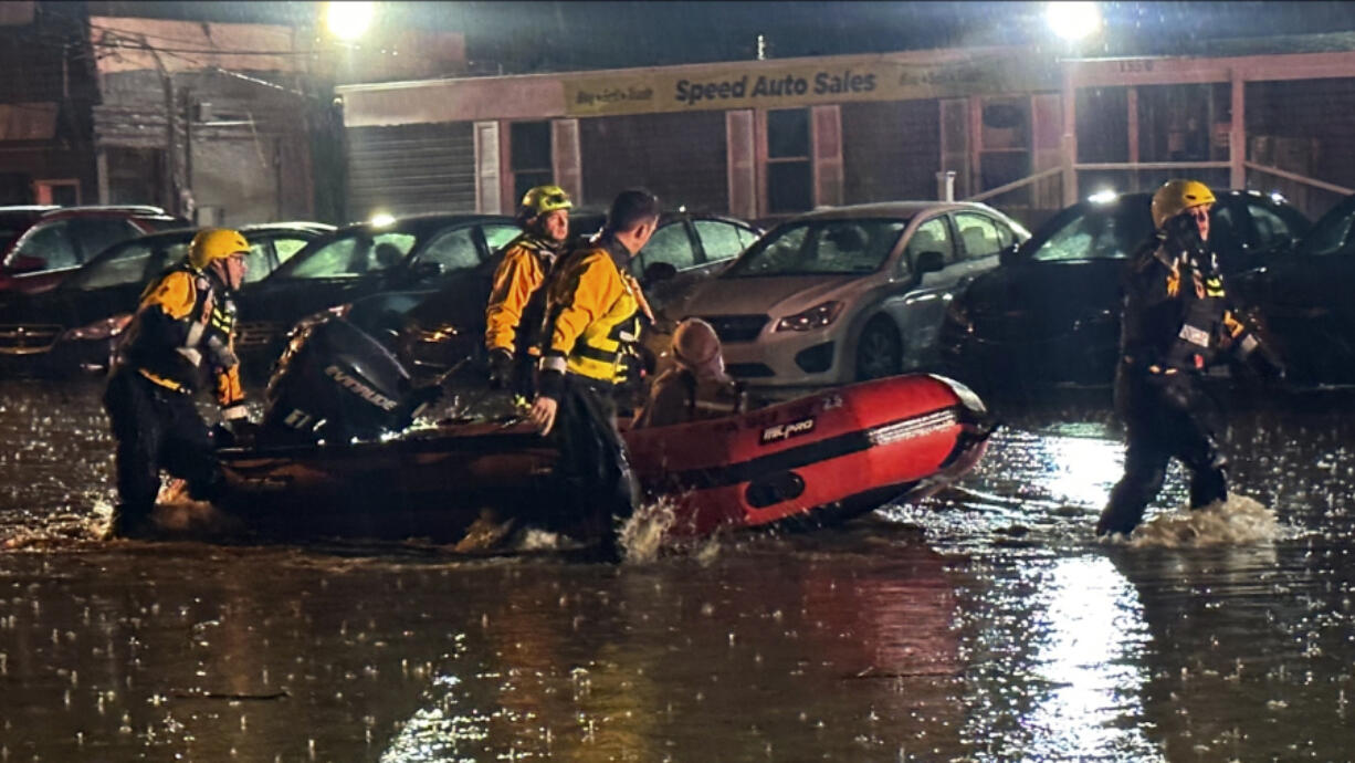 In this image provided by Pittsburgh Public Safety, Pittsburgh area water rescue team rescued a woman trapped in a car sinking in rising waters along a section of Route 51 east of the city Thursday night, April 11, 2024, in Pittsburg. Flash flooding caused by relentless heavy rains that soaked western Pennsylvania spurred numerous rescues and evacuations in the region, but no injuries were reported.