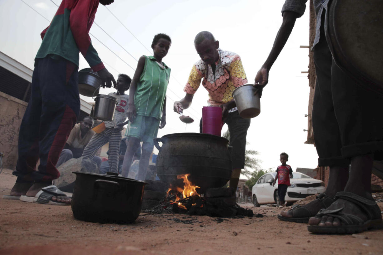 FILE - People prepare food in a Khrtoum neighborhood on June 16, 2023. Sudan has been torn by war for a year now, torn by fighting between the military and the notorious paramilitary Rapid Support Forces.