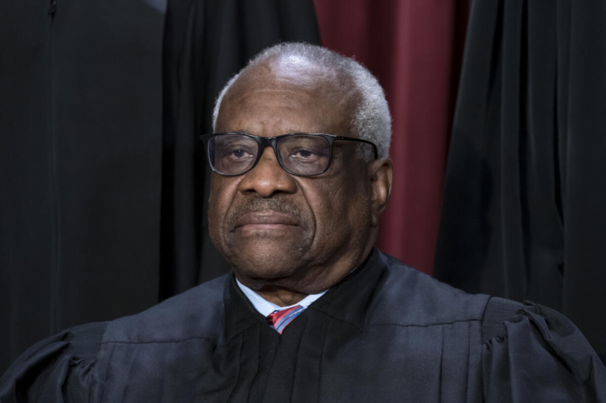 FILE - Associate Justice Clarence Thomas joins other members of the Supreme Court as they pose for a new group portrait, at the Supreme Court building in Washington, Oct. 7, 2022. Thomas is absent from the court Monday with no explanation. The 75-year-old Thomas also is not participating remotely in arguments, as justices sometimes do when they are ill or otherwise can&rsquo;t be there in person. Chief Justice John Roberts announced Thomas&rsquo; absence, saying that his colleague would still participate in the day&rsquo;s cases, based on the briefs and the transcripts of the arguments. (AP Photo/J.