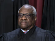 FILE - Associate Justice Clarence Thomas joins other members of the Supreme Court as they pose for a new group portrait, at the Supreme Court building in Washington, Oct. 7, 2022. Thomas is absent from the court Monday with no explanation. The 75-year-old Thomas also is not participating remotely in arguments, as justices sometimes do when they are ill or otherwise can&rsquo;t be there in person. Chief Justice John Roberts announced Thomas&rsquo; absence, saying that his colleague would still participate in the day&rsquo;s cases, based on the briefs and the transcripts of the arguments. (AP Photo/J.