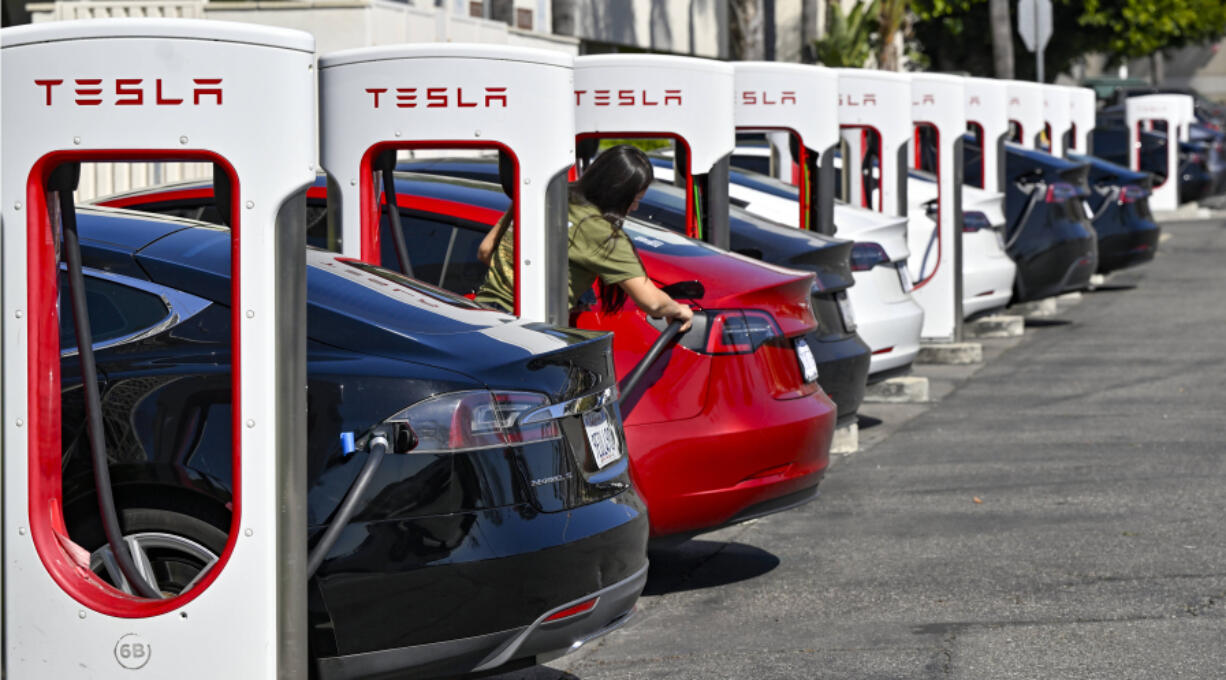 FILE - Drivers charge their Teslas in Santa Ana, Calif., on March 20, 2024.