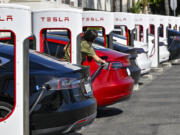 FILE - Drivers charge their Teslas in Santa Ana, Calif., on March 20, 2024.