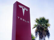 FILE - A Tesla sign is seen at a dealership, Dec. 3, 2023, in Buena Park, Calif. A Tesla that may have been operating on the company&rsquo;s Autopilot driving system hit and killed a motorcyclist near Seattle on Friday, April 19, 2024, raising questions about whether a recent recall went far enough to ensure that Tesla drivers using Autopilot pay attention to the road.
