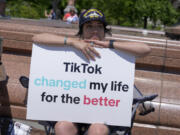 FILE - A TikTok content creator, sits outside the U.S. Capitol, April 23, 2024, in Washington.  TikTok is gearing up for a legal fight against a U.S. law that would force the social media platform to break ties with its China-based parent company or face a ban. A battle in the courts will almost certainly be backed by Chinese authorities as the bitter U.S.-China rivalry threatens the future of a wildly popular way for young Americans to connect online.