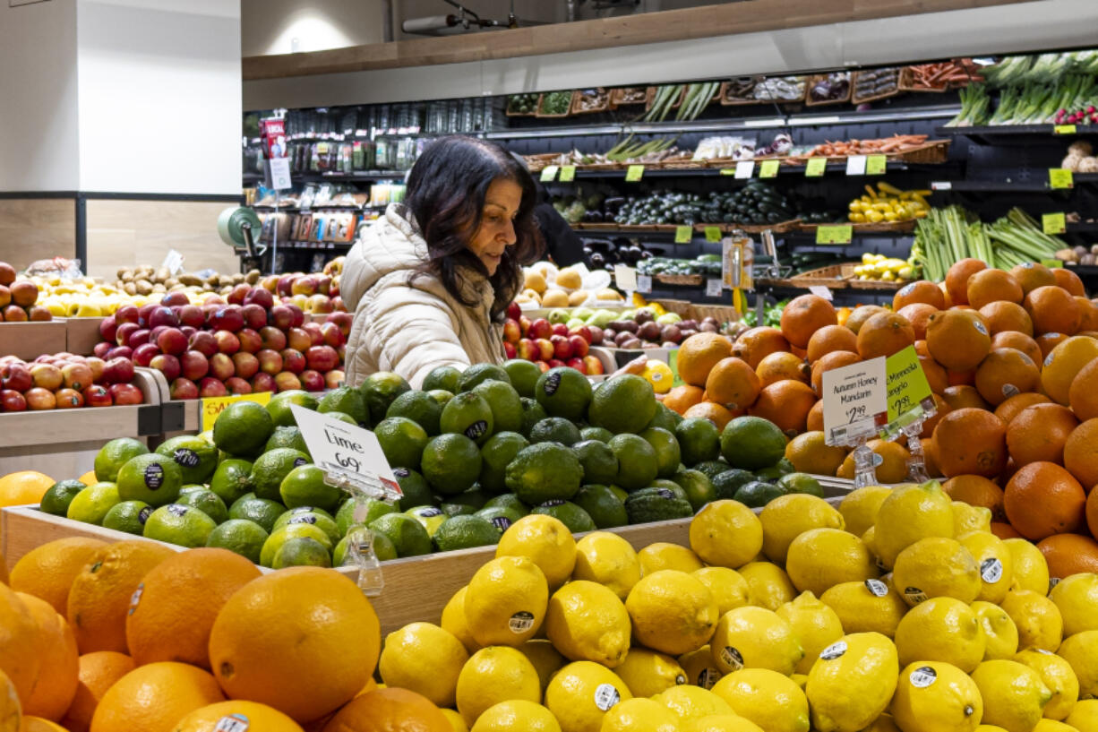 FILE - A woman browses produce for sale at a grocery store, Friday, Jan. 19, 2024, in New York. In final rule changes announced Tuesday, April 9, 2024, the federal program that helps millions of low-income mothers, babies and young kids will soon emphasize more fruits, vegetables and whole grains, as well as provide a wider choice of foods from different cultures. (AP Photo/Peter K.