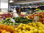 FILE - A woman browses produce for sale at a grocery store, Friday, Jan. 19, 2024, in New York. In final rule changes announced Tuesday, April 9, 2024, the federal program that helps millions of low-income mothers, babies and young kids will soon emphasize more fruits, vegetables and whole grains, as well as provide a wider choice of foods from different cultures. (AP Photo/Peter K.