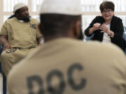 Sister Helen Prejean, right, talks April 22 as Richard Obot, left, detainee in Division Of Correction 11, listens to her during a book club at Department Of Corrections Division 11 in Chicago. (Nam Y.