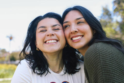 Friends Mary Delgado and Emmely Avila, left and right, pose for a portrait together where they first met at Echo Park Lake on Tuesday, April 16, 2024, in Los Angeles. Emmely is the founder and organizer of the Los Angeles Friends Club, a group designed to help people connect and she met her best friend Mary through the club.