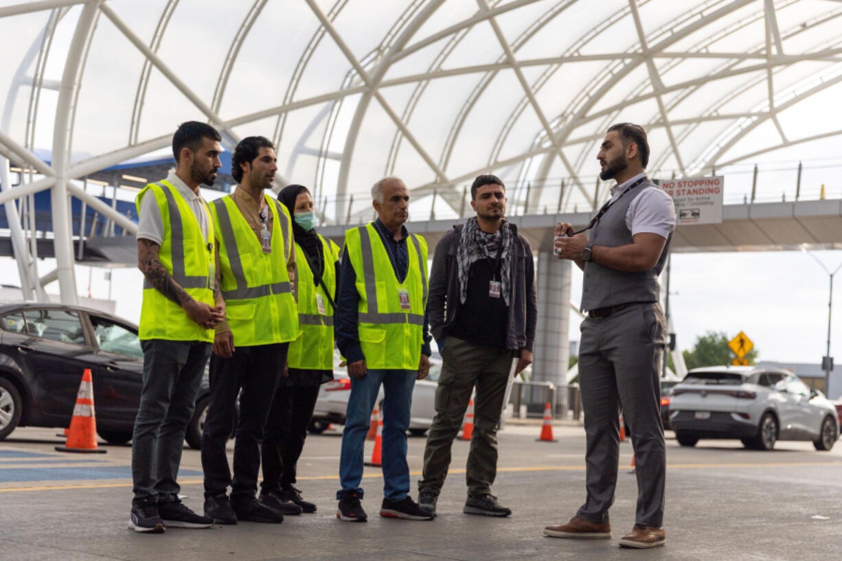 Mirwais Jalali, right, a recruiter for aviation contractor Unifi, prepares to give new employees a tour of the Hartsfield-Jackson airport in Atlanta on April 19, 2024.