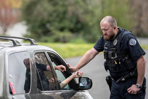 Vancouver police Officer Cole Larson talks with a motorist before confiscating a device used to smoke fentanyl and issuing a citation on April 4. Therapeutic drug courts have seen lower participation since decriminalization of drug possession.
