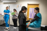From left: Cascadia Tech Academy student Hannah Freimuth, 18, has her height and weight measured by classmate Leslie Vega, 17, as Unzila Alauddin, 17, takes the blood pressure of fellow student Mia Yanez, 18, on Friday afternoon. The medical assisting program at Cascadia Tech Academy allows students to gain clinical experience at local clinics and hospitals.