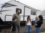 Dylan Bowling, 8, from left, joins father, Chris Bowling, 39, sister, Emma, 13, brother, Wyatt, 10 months, and mother, Crystal Bowling, 38, as they take a break with their recreational vehicle in Ridgefield before dropping it off at the dealership. The family of five moved from a home in California to Clark County for the husband to accept a new job but had trouble finding housing they could afford.