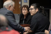 Defense attorneys Ed Dunkerly, from left, and Michele Michalek meet with defendant Julio Segura before opening statements Monday morning in his murder trial for the 2022 death of Vancouver police Officer Donald Sahota at the Clark County Courthouse.