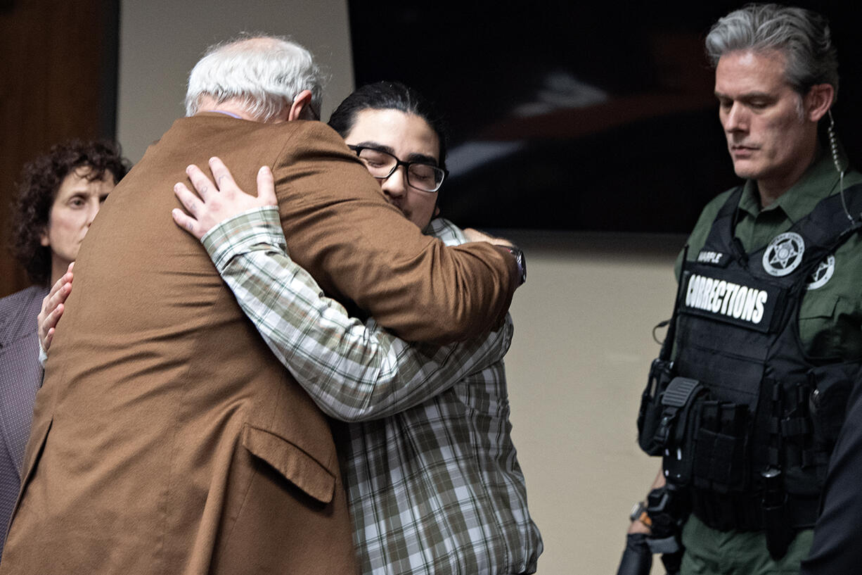 Julio Segura, facing, gets support from his defense attorney Ed Dunkerly following the verdict in his murder trial at the Clark County Courthouse on Friday afternoon. A jury convicted Segura of murdering off-duty Vancouver police Officer Donald Sahota.